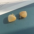 Coppia di ciondoli a cuore in pietra naturale gialla con ganci dorati su fondo blu - Topazio