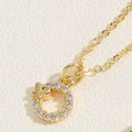 Macro detail of a gold circle necklace featuring a zircon-studded butterfly pendant - Butterfly Zirconia (14K Gold Plated)