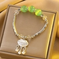 Silver bow bracelet with green cat's eye beads and traditional long-life lock pendant - Silver Longevity Lock Bell Bracelet (X755)