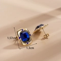 Elegant gold earrings with rectangular blue gemstones and crystal accents in front view - Dark Blue Rectangular Gemstone Stud Earrings
