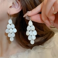 Primer plano de pendientes colgantes de gotas blancas con un acabado perlado de nácar - Estilo de Gota con Textura de Concha Escalonada en Forma de Lágrima (12#) / Blanco