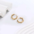 Close-up of golden hexagonal U-shaped earrings with polished finish on white prop - Pentagonal