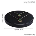 Golden emerald crown necklace with intricate twisted chain on a black display base - Large Round Base Plate (Black)