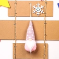 Pink knitted Christmas gnome ornament with white polka dots hanging on rustic display - Pink Type C