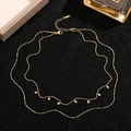 Double-layered gold titanium steel necklace with rhombus charms on black textured background - Gold