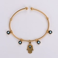 Detailed view of golden twisted cable Hamsa Hand bangle with blue Evil Eye charms - Gold Hamsa Hand