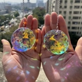 Pair of K9 crystal prism suncatchers reflecting vibrant rainbow light on hands - Circular 45mm