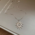 Zilveren zonnehanger ketting met spiraal en kralen slangenketting op een boek - Ketting - Zilver