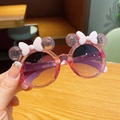 Detailed view of pink glittery round sunglasses with cartoon ears and bow decoration - Pink