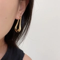 Close-up of woman wearing a minimalist 18K gold plated U-shaped geometric earring - Cast U-shaped Earrings Gold