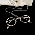Gros plan d'un collier pendentif lunettes argenté rétro sur fond de velours noir - Argenté