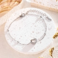Minimalist stainless steel heart charm bracelet on white stone with floral accents - Heart Bracelet / Silver
