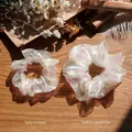 Set of two white organza scrunchies with iridescent laser finish on a vintage wooden desk - Fashion Large Size