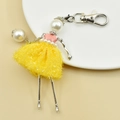 Detail of handmade ballerina keychain with yellow tutu and pearl head on ceramic plate - 05-Yellow Mesh Ballet Dancer