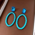 Detailopname van vintage oorbellen met blauwe kristallen kralen en grote ovale hangers - Zilveren oorknopjes stijl / Blauw