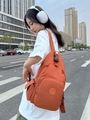 Outdoor street shot of a versatile orange Oxford fabric multi-way backpack for daily use - Orange Red