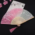 Classic folding fan with pink gradient cherry blossom pattern and wood carving - Pink Petals Dancing
