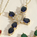 Macro shot of gold cross pendant with blue teardrop stones and Virgin Mary relief - Blue