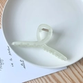 Minimalist matte light green large hair claw clip on a white ceramic plate - Crossed / Yellow