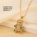 Detailed close-up of a gold-plated bear pendant necklace with green heart zirconia - Gold - Green Hearts Limbs Bear