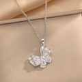 Brushed butterfly pendant necklace with white zircon stones on a champagne satin background - Silver