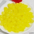 Detailed view of yellow 6x8mm barrel beads with jade-like texture in a petal bowl - Lemon Yellow