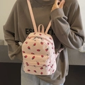 Pink corduroy mini backpack with strawberry pattern worn by a model on back - Pink