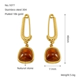 Macro detail of paperclip earrings with amber natural stone and 18k gold plating - Gold