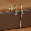 Macro shot of S925 engraved stamp on gold zircon earrings set against brown leather - Gold-Blue