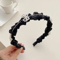 Elegant black pleated headband featuring pearl bow and rhinestone details in a lifestyle setting - 220539 Black