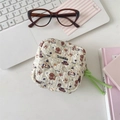 Detailed shot of a quilted cream sanitary storage pouch with cute brown puppy patterns - Skating Dog