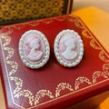 Vista macro de pendientes camafeo vintage con perlas blancas y borde dorado en joyero - Retrato de Cameo Rosa (1# Aguja de Plata-Rosa)