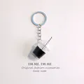 Close-up of a miniature iced drink keychain with coffee and a striped straw detail - Black