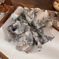 Detail of Chinese ink calligraphy fabric scrunchie on a decorative wooden tray - Cranes in Clouds (Dark Green Landscape)