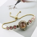 Detail of pink crystal bracelet watch featuring a petal-shaped bezel and adjustable gold chain - Gold Pink