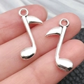 Silver musical note pendants for DIY jewelry making shown in hand for size comparison - Music Note (8x24mm-1g)