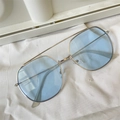 Flat lay of blue cat-eye sunglasses with silver metal frame on white fabric - Metal Aviator Sunglasses Blue