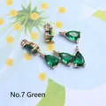 Detailed macro view of five green waterdrop glass pendants with gold plated frames - 4*8mm / Green