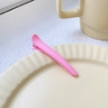 Single matte pink duckbill hair clip on a minimalist ceramic plate display - Pink