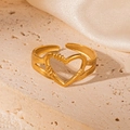 Adjustable golden hollow heart ring with unique texture on textured beige stone base - Heart Gold 58