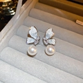 Macro shot of silver butterfly earrings with zircons and white pearls in a jewelry box - Silver Butterfly Double Pearl Studs