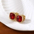 Détail macro d'une boucle d'oreille rubis carré avec serti doré et halo de diamants - Rouge