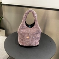 Detail of pink rhinestone bucket bag featuring a blue magnetic closure and black lining - Pink