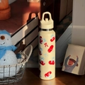 Detail der cremefarbenen Edelstahlflasche mit Kirschmuster in gemütlicher Atmosphäre - 750ml / Kirsche