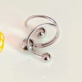 Macro di un anello a spirale d'argento con sfere lucide su superficie bianca - Argento