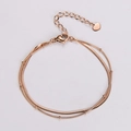 Dettaglio bracciale a doppio strato in oro rosa con perline e ciondolo a cuore - Oro rosa