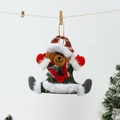 Close-up of green plush Christmas bear ornament with red heart and festive decorations - Bear
