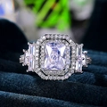 Luxury emerald cut zircon halo ring in silver finish on navy blue velvet display - US 9 / White Gold