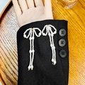 Elegantes pendientes de perlas con borlas y lazo dorado sobre fondo de tela negra - Estilo de Borla con Lazo Clásico (E6078-1)