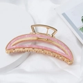Detail of a large golden metal hair claw clip with pink marble inlay on white silk - Pink